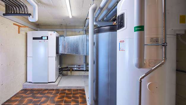 Im Technikraum sind Wärmepumpe, Heizungsspeicher (grau) und Wärmepumpenboiler (weiss) untergebracht.